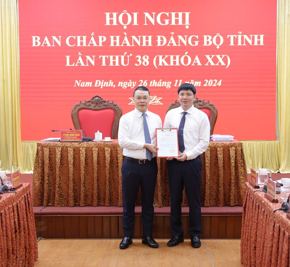 Bí thư Tỉnh ủy Nam Định Đặng Khánh Toàn (bên trái) trao quyết định của Ban Bí thư Trung ương Đảng tới ông Nguyễn Hoàng Anh. Ảnh: Duy Hưng