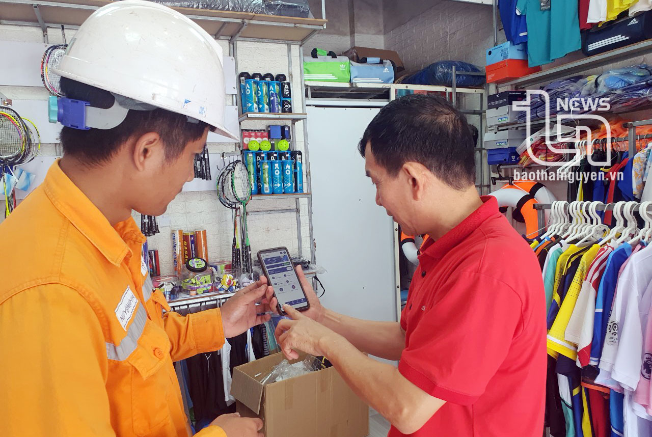 Công nhân Điện lực Thái Nguyên hướng dẫn khách hàng cài đặt APP CSKH để nhận thông báo điện miễn phí.