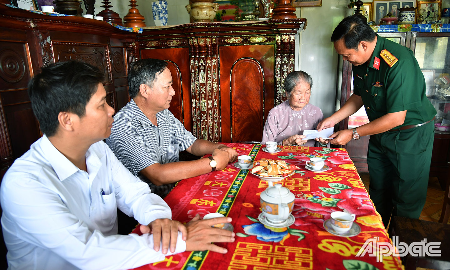 Đại tá Phạm Văn Thanh, Ủy viên Ban Thường vụ Tỉnh ủy, Chỉ huy trưởng Bộ CHQS tỉnh thăm, tặng quà cho bà Nguyễn Thị Sòi (vợ liệt sĩ Lương Văn Quới), ngụ ấp Cả Thu 2, xã Phú Thạnh, huyện Tân Phú Đông. Ảnh: THANH LÂM