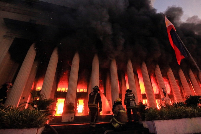 Lính cứu hỏa dập lửa tại Bưu điện Trung tâm Manila, thủ đô Philippines, rạng sáng 22/5. Ảnh: AFP