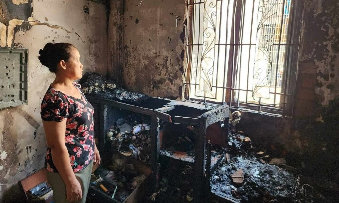 Bà Trang đứng trong phòng bị cháy lan từ ngôi nhà cấp 4 làm mẹ con tử vong, sáng 28/6. Ảnh: Đình Văn