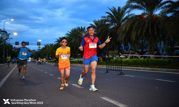 HLV Trần Văn Sỹ và con trai trên đường chạy VnExpress Marathon Sparkling Quy Nhơn 2023. Ảnh: VM