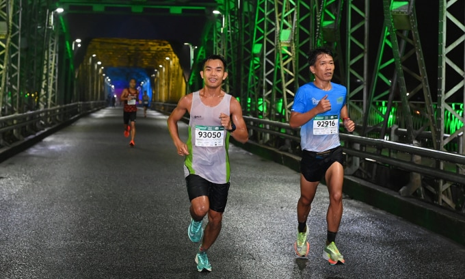 Huỳnh Thạnh (trái) trên đường chạy VnExpress Marathon Huế 2023. Ảnh: VM