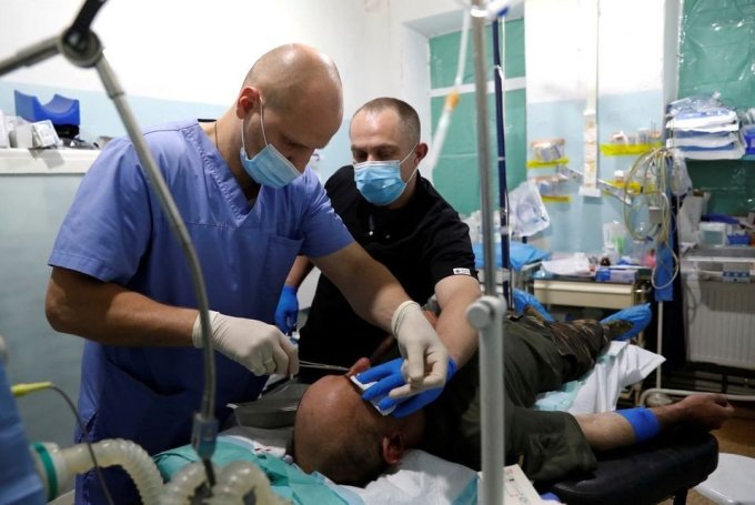 Bác sĩ phẫu thuật đang điều trị cho thương binh Ukraine tại một khu điều trị khẩn cấp ở Zaporizhzhia vào tháng 5. Ảnh: Reuters