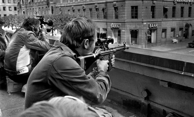 Các nhiếp ảnh gia báo chí và cảnh sát bắn tỉa ngồi cạnh nhau trên mái nhà đối diện ngân hàng Sveriges Kreditbank, vào ngày thứ hai của vụ cướp. Ảnh: AFP