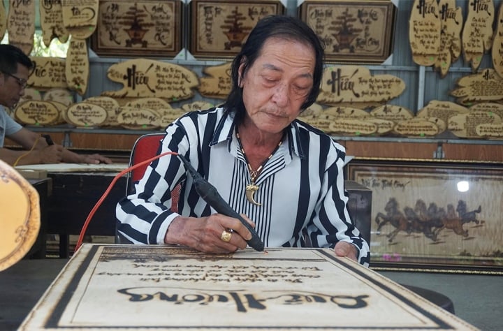 Nghệ nhân Trương Vũ Kha (Dzũ Kha) đang thực hiện những tác phẩm thơ Hàn Mạc Tử trên gỗ thông bằng ngòi bút lửa độc đáo do mình chế tác.