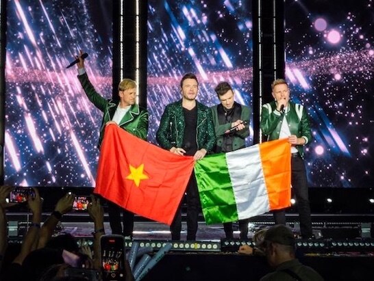 Ban nhạc Westlife trân trọng giương cao lá cờ Việt Nam cùng cờ Ireland và cúi chào khán giả. Ảnh: VPBank