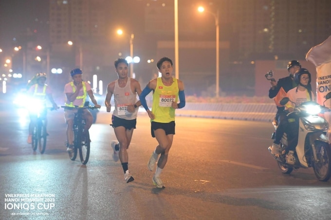 Nguyễn Trung Cường (áo xanh) và Hà Văn Nhật (áo trắng) song hành cùng nhau suốt 21km. Ảnh: VM