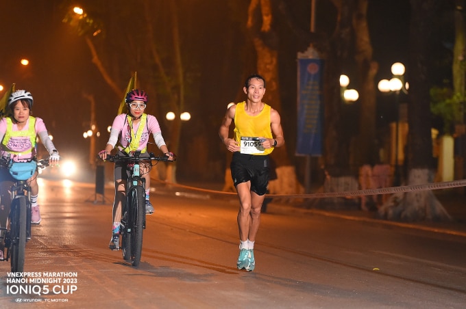 Trương Văn Quân chạy cùng đội xe đạp tại VM Hanoi Midnight 2023.