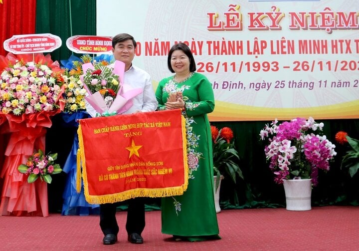 Chủ tịch Liên minh HTX Việt Nam Cao Xuân Thu Vân trao Cờ thi đua cho đại diện Quỹ tín dụng nhân dân Bồng Sơn.