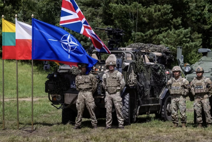 Binh sĩ Anh và Mỹ bên cạnh cờ NATO. (Ảnh: Sputnik)