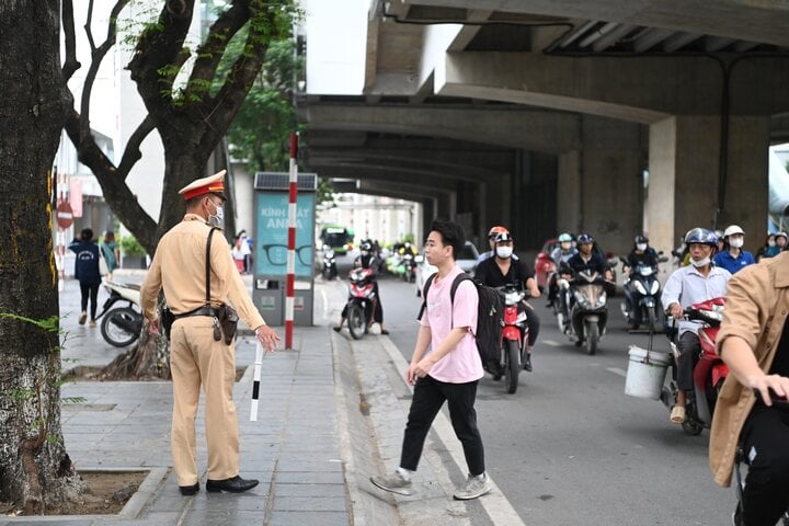 Cán bộ Đội CSGT số 6, Phòng CSGT Công an TP Hà Nội xử phạt nam sinh đi bộ không đúng quy định trên đường Xuân Thuỷ.
