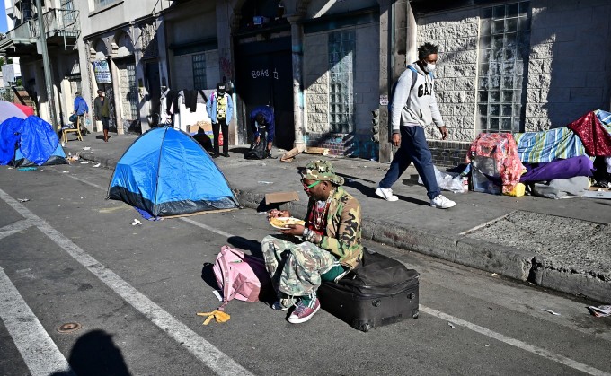 Lều bạt, chăn màn, quần áo của người vô gia cư giăng khắp một con phố ở Los Angeles ngày 22/11. Ảnh: AFP