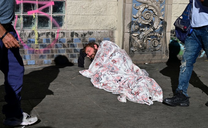 Một người đàn ông vô gia cư ngủ trên vỉa hè Los Angeles, bang California, ngày 22/11. Ảnh: AFP