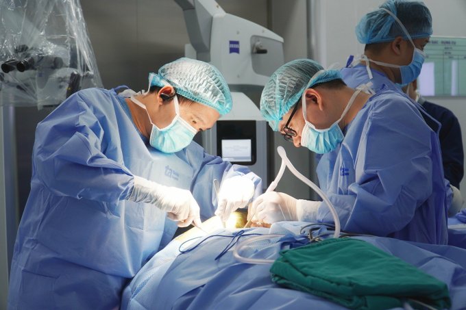 Bác sĩ Đức Anh (trái) cùng ê kíp phẫu thuật thay đốt sống cổ nhân tạo cho ông Hà. Ảnh: Bệnh viện cung cấp