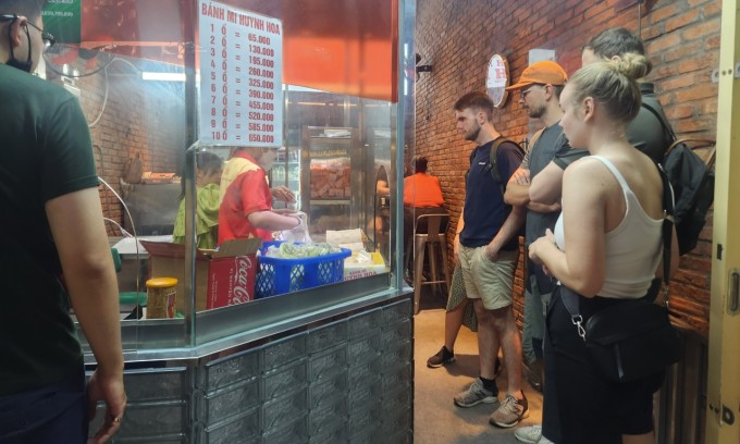 Khách nước ngoài xếp hàng chờ mua bánh mì ở tiệm Huỳnh Hoa, quận 1. Ảnh: Bích Phương