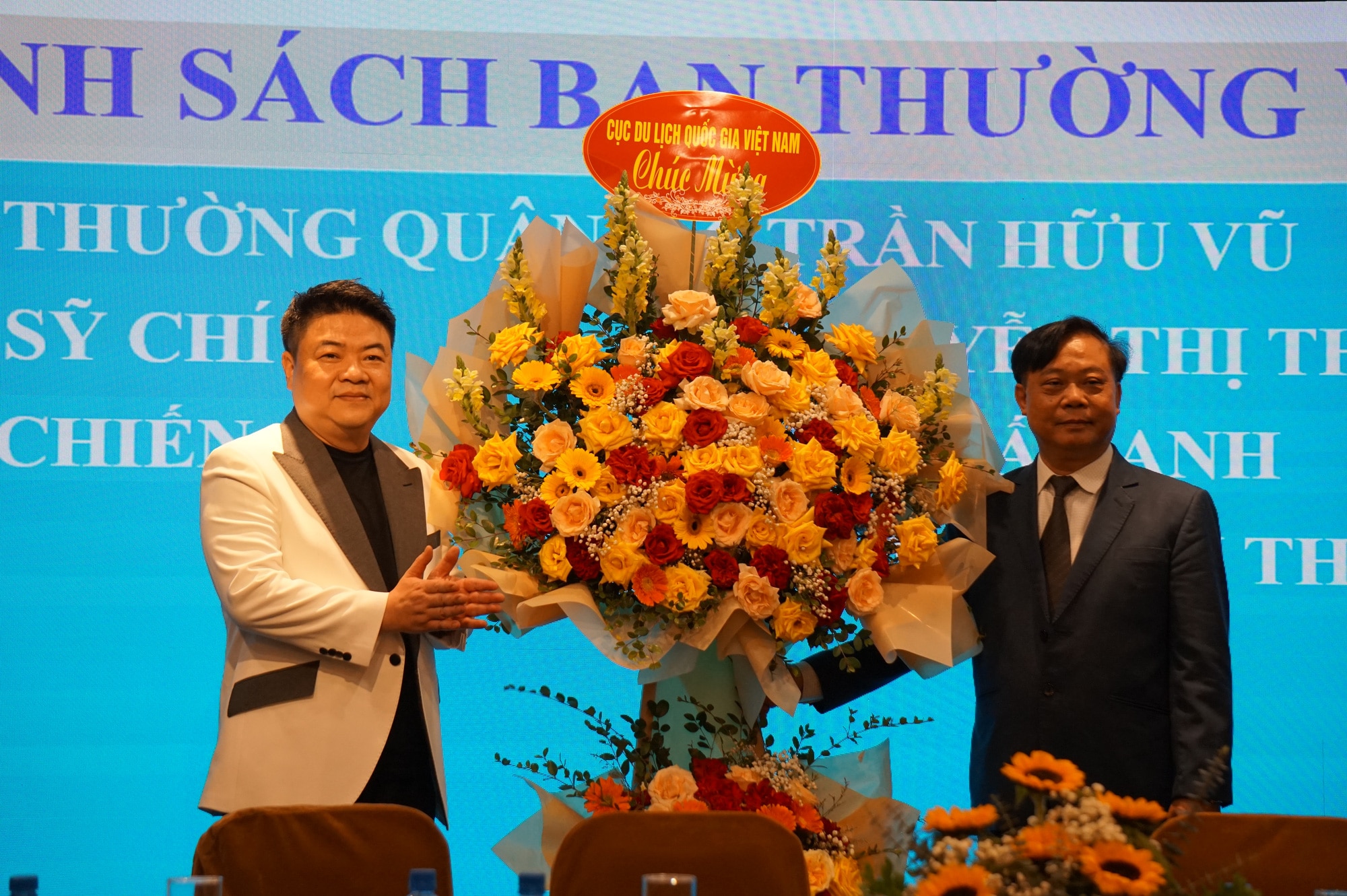 Phó cục trưởng Cục Du lịch quốc gia Phạm Văn Thủy (phải) tặng hoa tân chủ tịch Hiệp hội Dạy nghề và việc làm đầu bếp Việt Nam - Ảnh: T.ĐIỂU