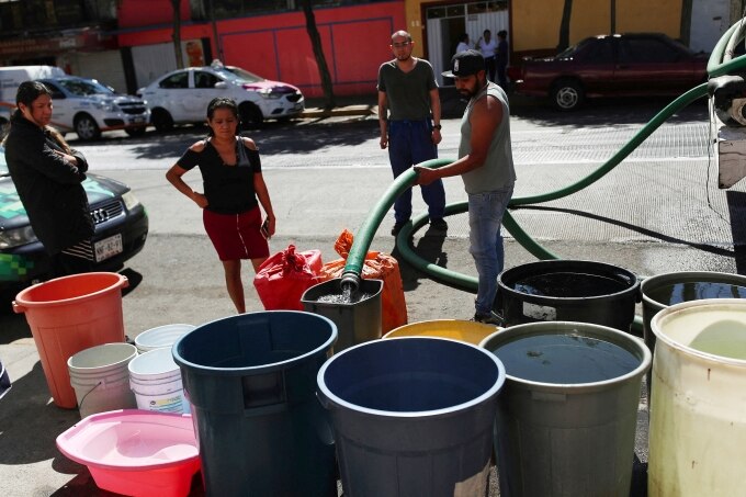 Người dân hứng nước từ xe tải ở khu phố Azcapotzalco, thủ đô Mexico City, ngày 26/1. Ảnh: Reuters