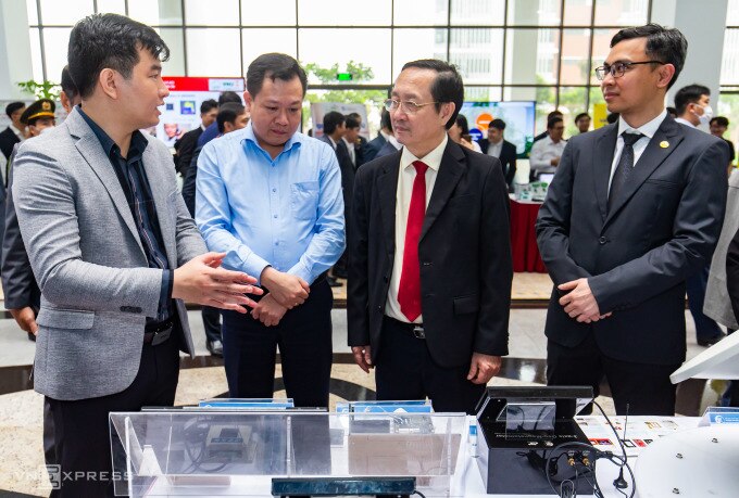 Bộ trưởng Huỳnh Thành Đạt (thứ ba từ trái sang) tham quan triển lãm Công nghệ chip bán dẫn với hàng chục gian hàng giới thiệu công trình nghiên cứu, mô hình sản phẩm có tính ứng dụng cao tại Đại học Quốc gia Hà Nội hồi tháng 4/2023. Ảnh: Tùng Đinh