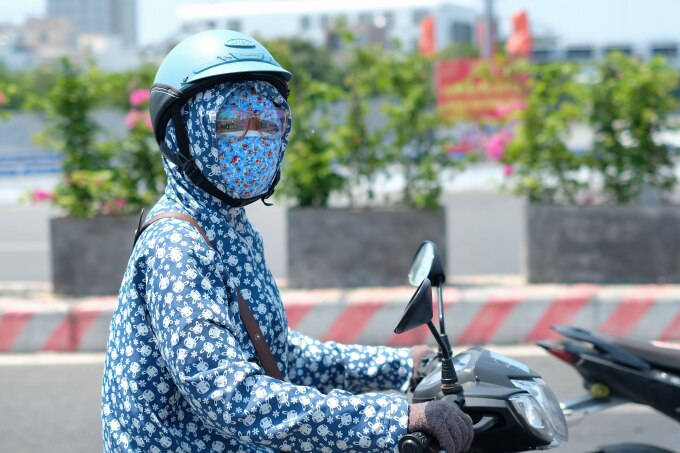 Người dân Đà Nẵng ra đường giữa buổi trưa đều bịt kín người bằng áo chống nắng. Ảnh: Nguyễn Đông