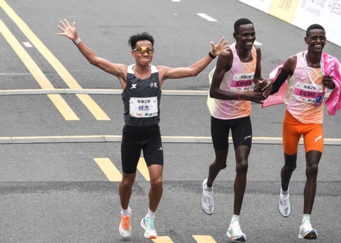He Jie (áo đen) mừng sau khi về đích ở Wuxi Marathon 2024 ngày 24/3. Ảnh: Xinhua