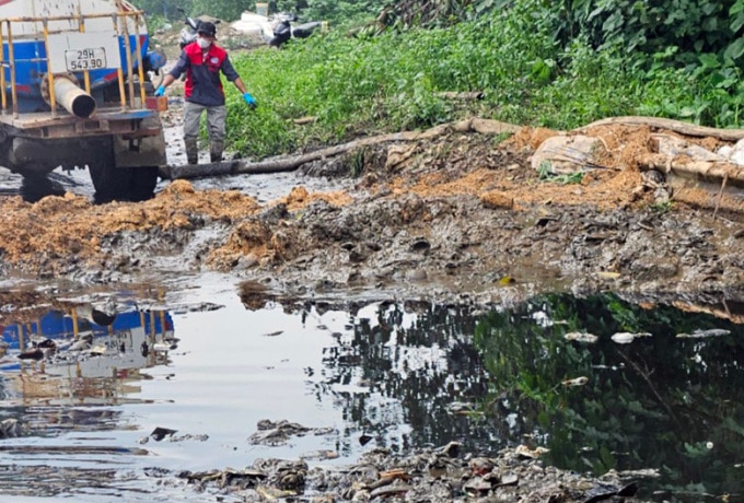 Đơn vị quản lý dùng xe hút nước thải tràn ra khu vực đường nội bộ của bãi rác Nam Sơn. Ảnh: Hoàng Phong