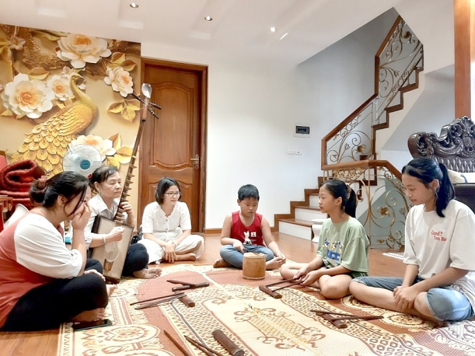 Nghệ nhân Nguyễn Thị Tam đang truyền dạy hơn ca trù cho học trò Ảnh: N.M  