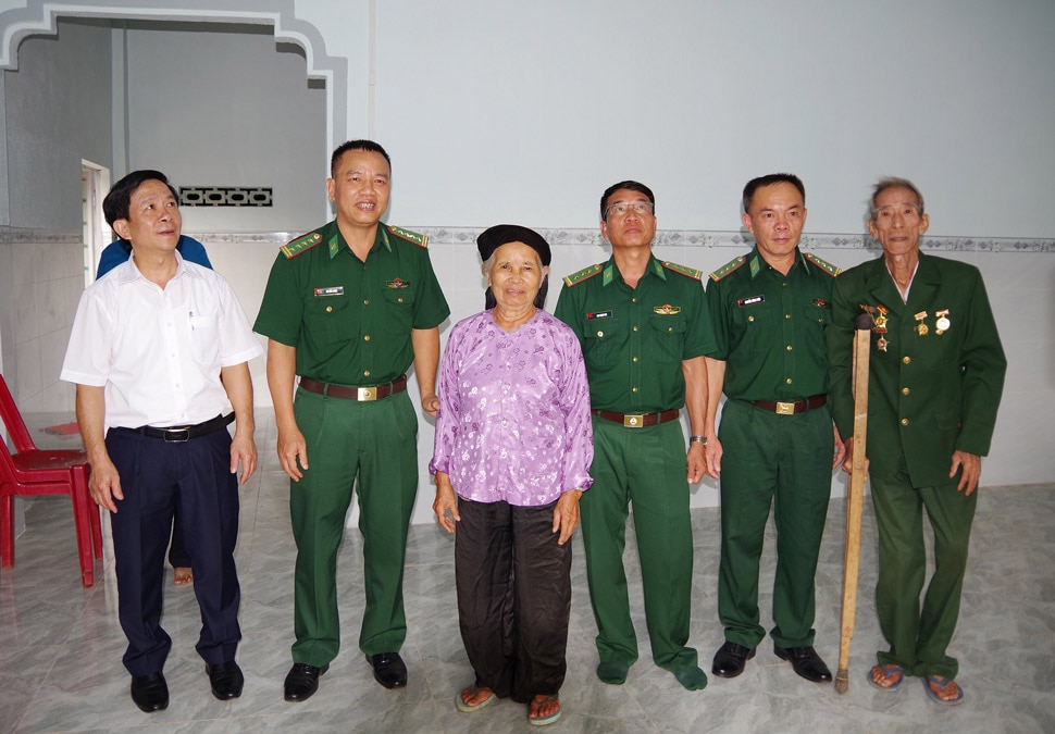 Bộ đội Biên phòng, chính quyền địa phương cùng gia đình ông Trương Quang Tỉnh trong căn nhà mới. ẢNH: PV