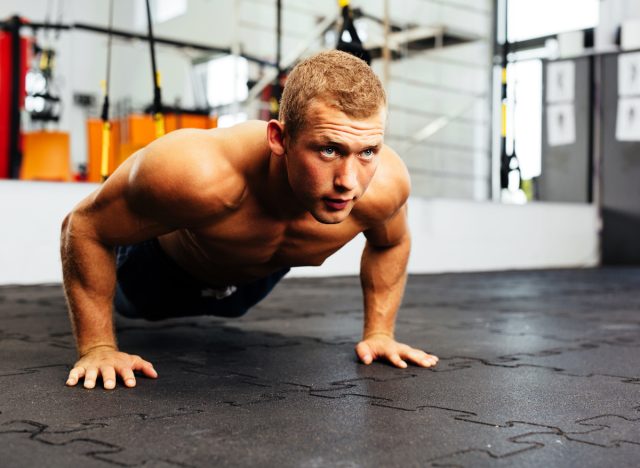 người đàn ông cơ bắp tập chống đẩy tại phòng tập thể dục, khái niệm về các bài tập hàng ngày cho nam giới để giữ dáng