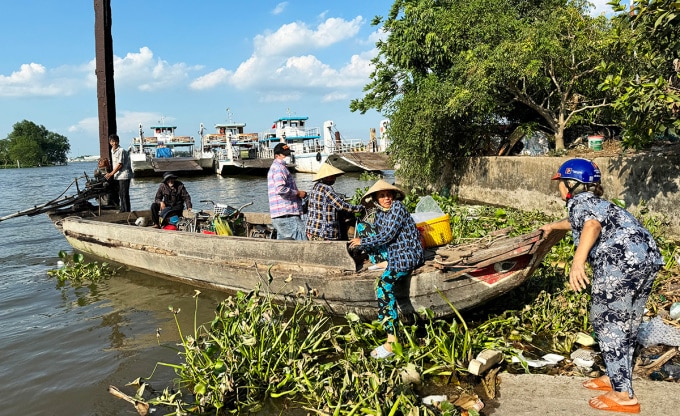 Người dân xuống ghe nhỏ vượt sông Hậu về TX Bình Minh trong khi ba chiếc phà 90-110 tấn phải neo đậu tại bến. Ảnh: An Bình