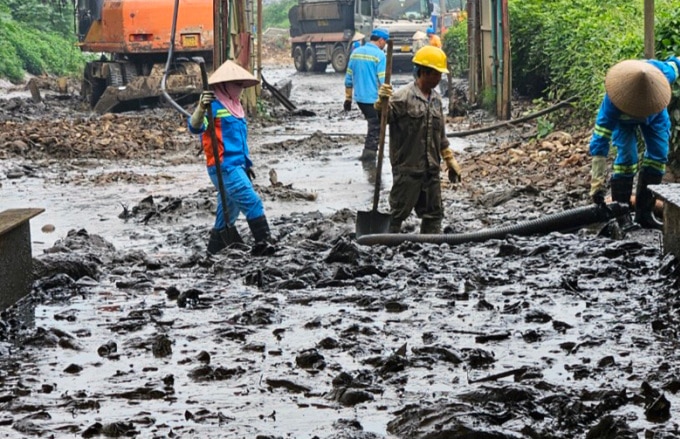 Công nhân khắc phục sự cố tràn bùn thải ở bãi rác Nam Sơn, sáng 4/5. Ảnh: Hoàng Phong