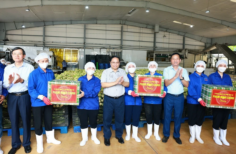 Thủ tướng Phạm Minh Chính tặng quà cho công nhân Công ty cổ phần thực phẩm xuất khẩu Đồng Giao. (Ảnh: Dương Giang/TTXVN)