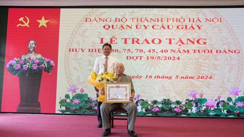 Trưởng Ban Tổ chức Thành ủy Vũ Đức Bảo trao Huy hiệu 80 năm tuổi và chúc mừng đảng viên lão thành Trần Quang Nghĩa.