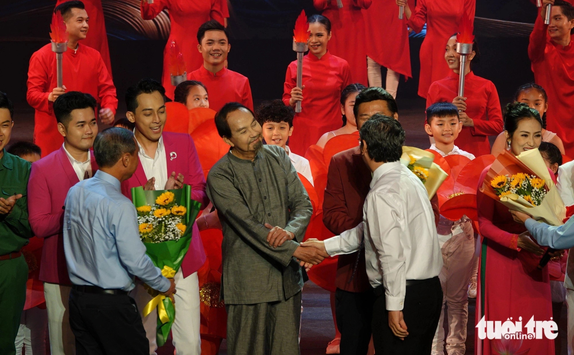 Lãnh đạo thành phố tặng hoa chúc mừng nghệ sĩ Thanh Điền trong vai diễn hình tượng Bác Hồ - Ảnh: T.T.D.
