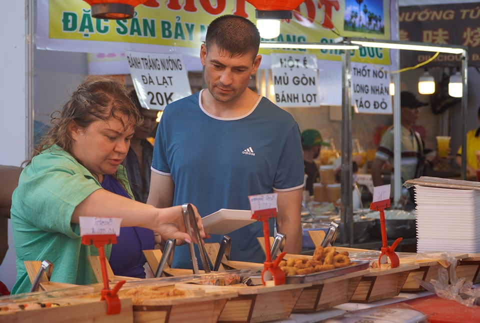 Du khách quốc tế thích thú trải nghiệm ẩm thực địa phương tại Liên hoan Du lịch Biển Nha Trang 2024.