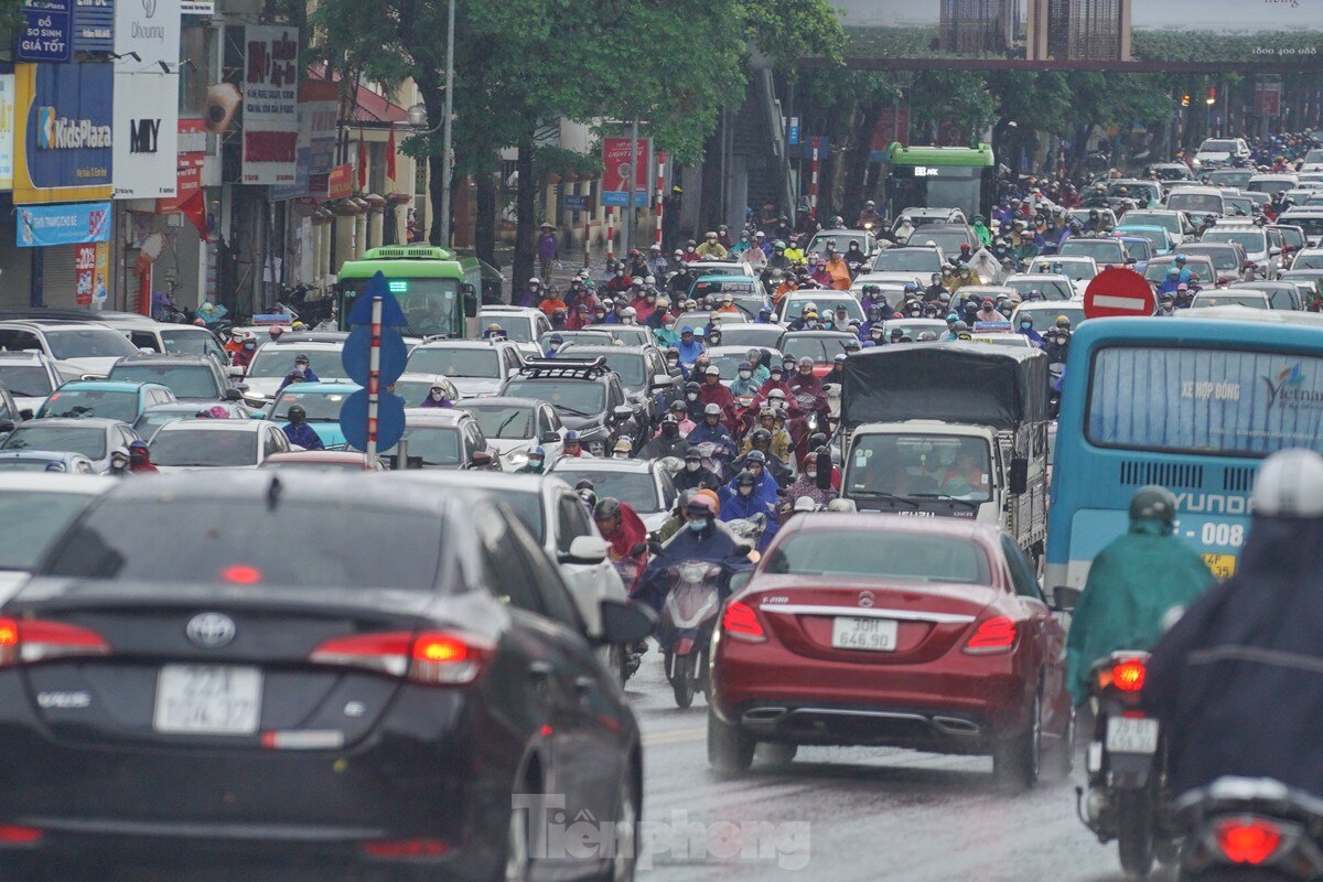 Жители Ханоя с трудом идут на работу под проливным дождем - Vietnam.vn