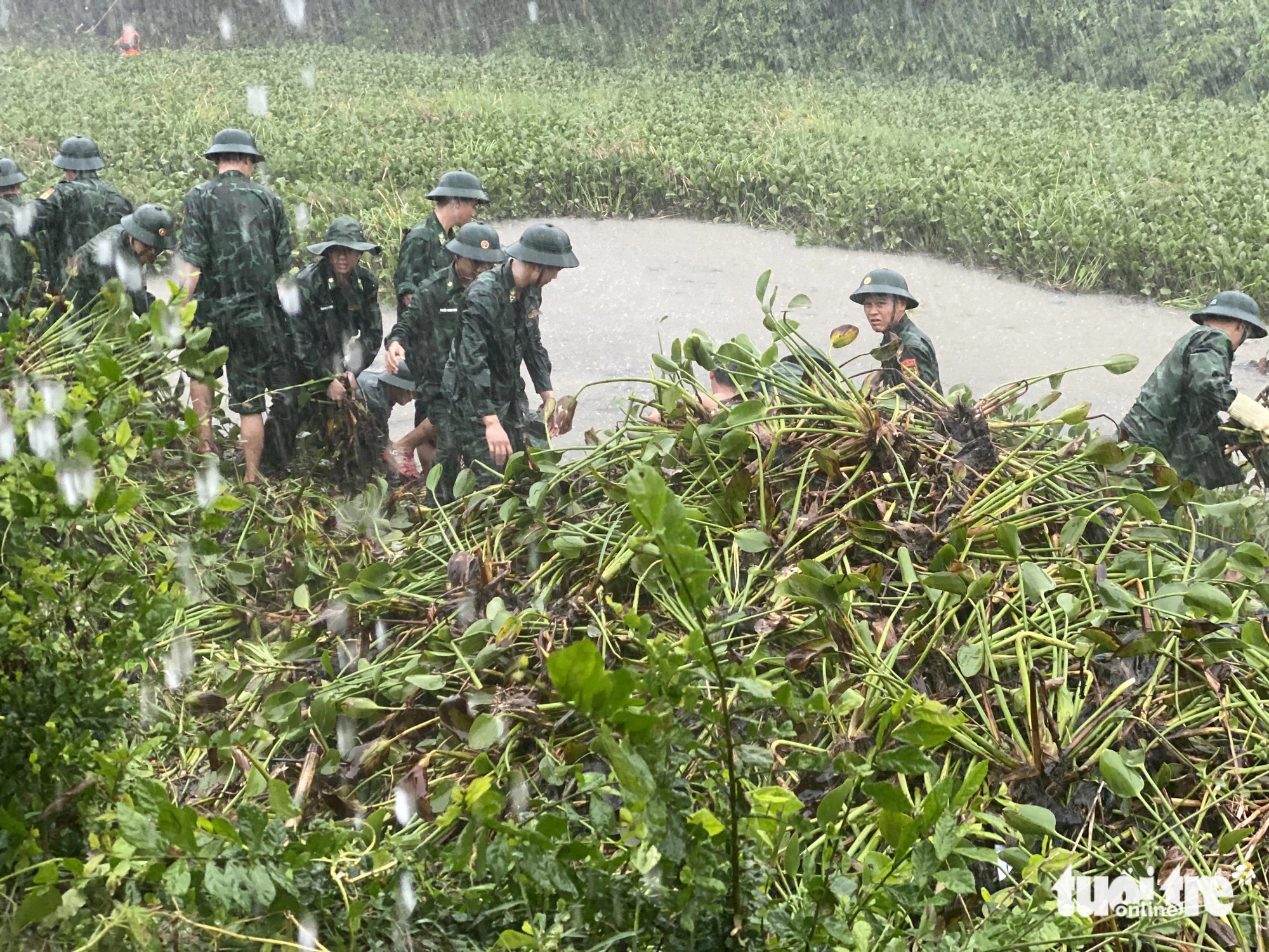 Ngay ngày đầu tiên ra quân, trời mưa lớn nhưng các bạn trẻ tình nguyện vẫn tích cực triển khai công việc - Ảnh: ĐOÀN NHẠN