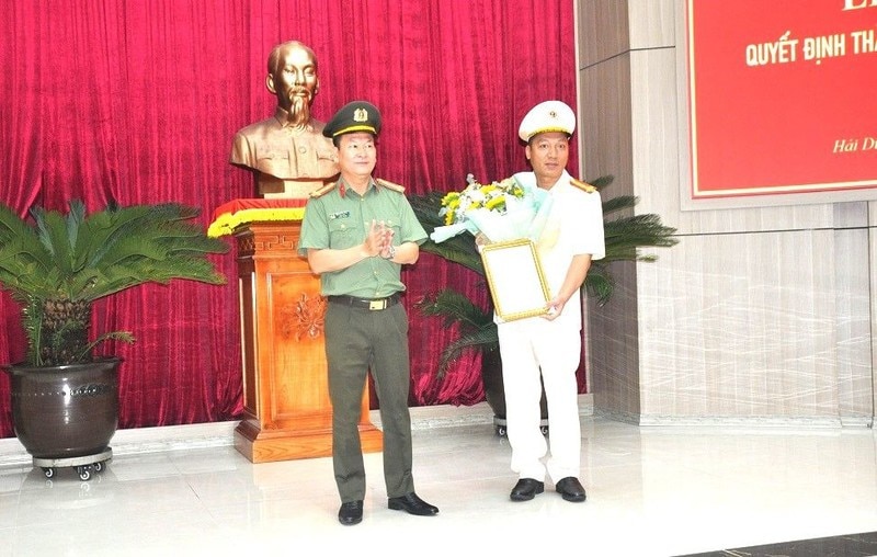 Đại tá Bùi Quang Bình, Giám đốc Công an tỉnh Hải Dương trao quyết định và tặng hoa chúc mừng Đại tá Phạm Chí Hiếu. 