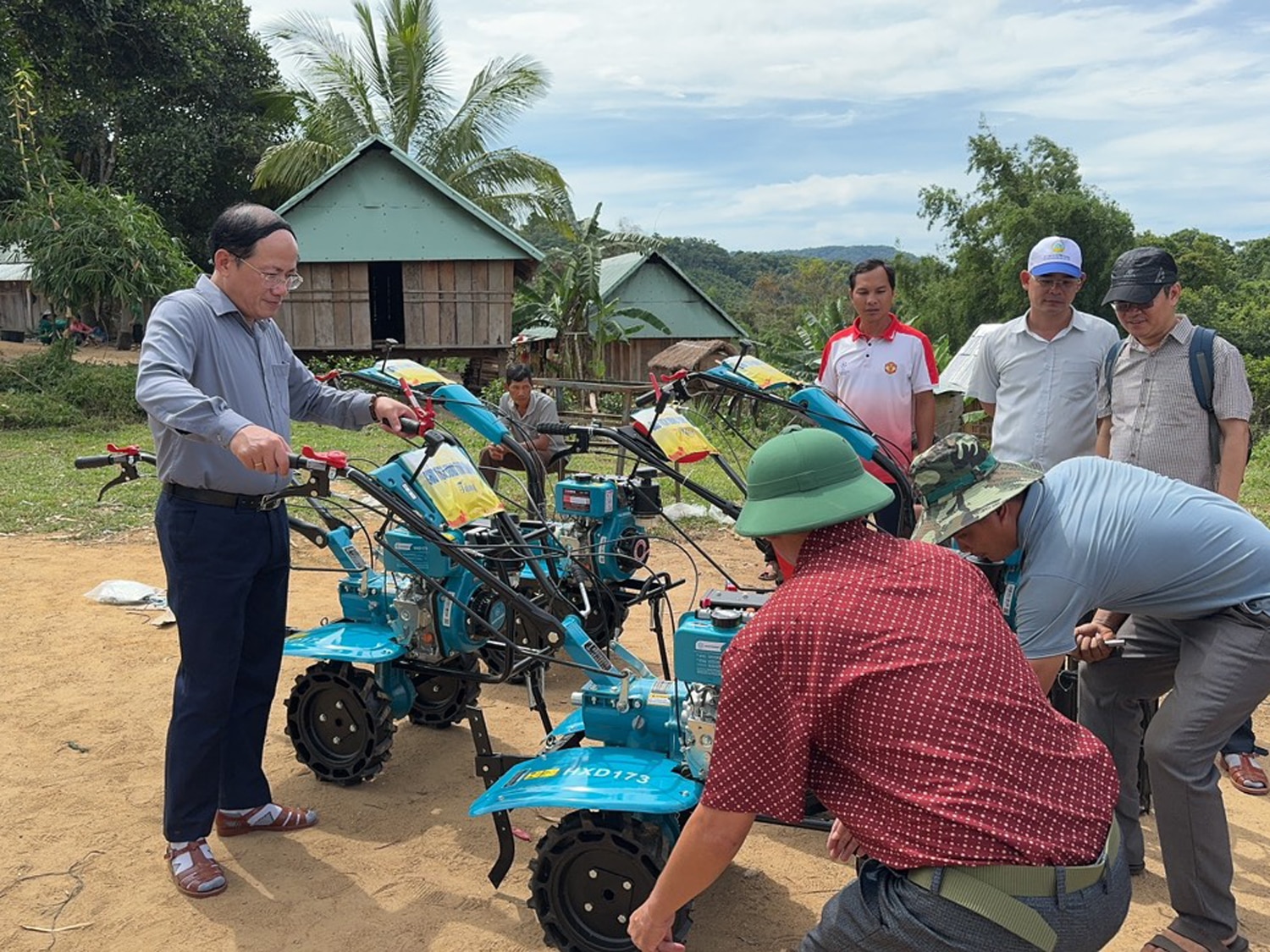 Chủ tịch UBND tỉnh Bình Định Phạm Anh Tuấn (bìa trái) tặng 5 máy cày cầm tay cho người dân thôn O2