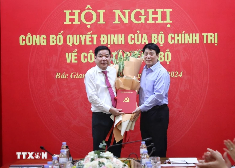 Ông Lương Cường (phải), Ủy viên Bộ Chính trị, Thường trực Ban Bí thư tặng hoa và trao quyết định cho đồng chí Nguyễn Văn Gấu nhận trọng trách mới. (Ảnh: Danh Lam/TTXVN)