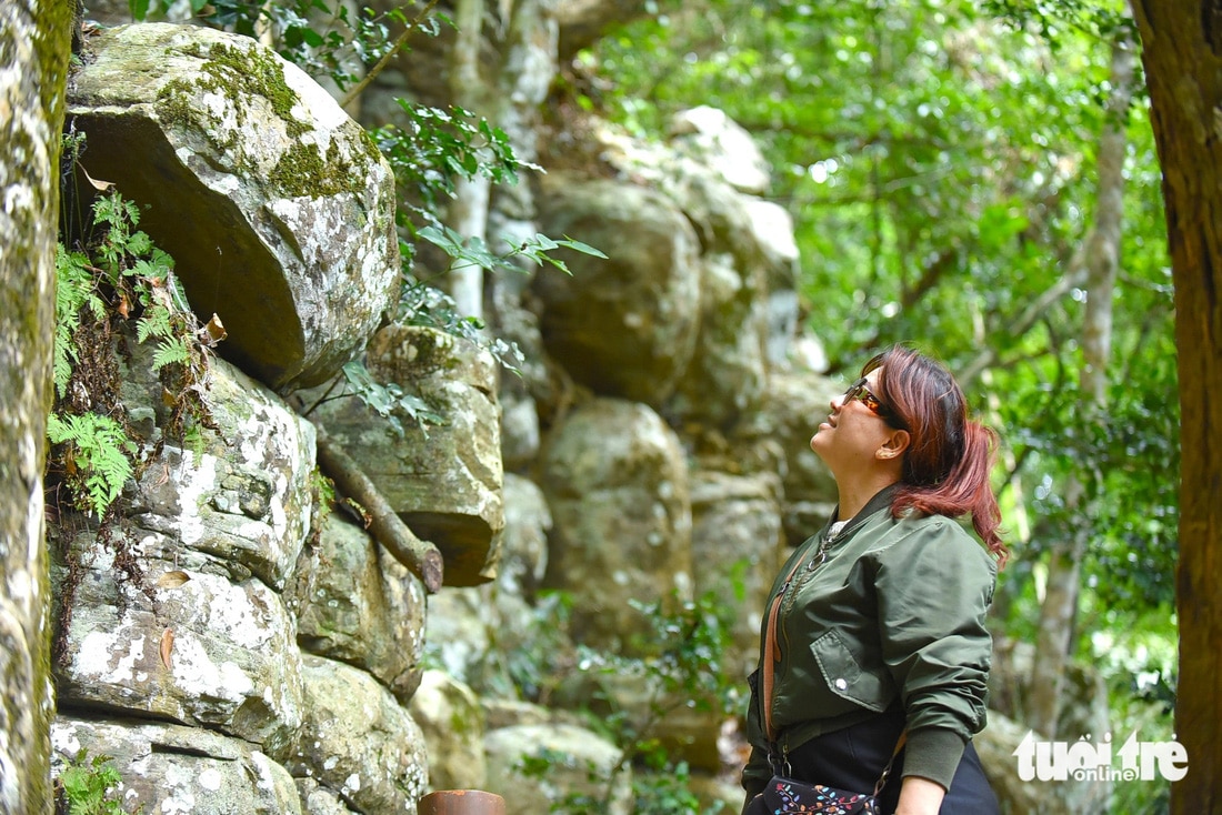 Một nữ du khách tò mò, thích thú trước vẻ đẹp của những khối đá và cách chúng nối liền với nhau - Ảnh: LÂM THIÊN