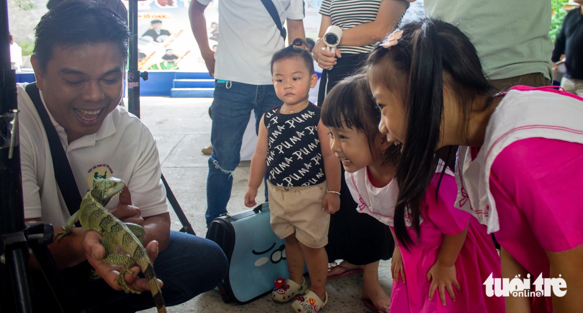Các bạn nhỏ thích thú với chú kỳ nhông tại gian triển lãm của Lễ hội Cá cảnh Thú cưng TP.HCM- Ảnh: TÔ CƯỜNG