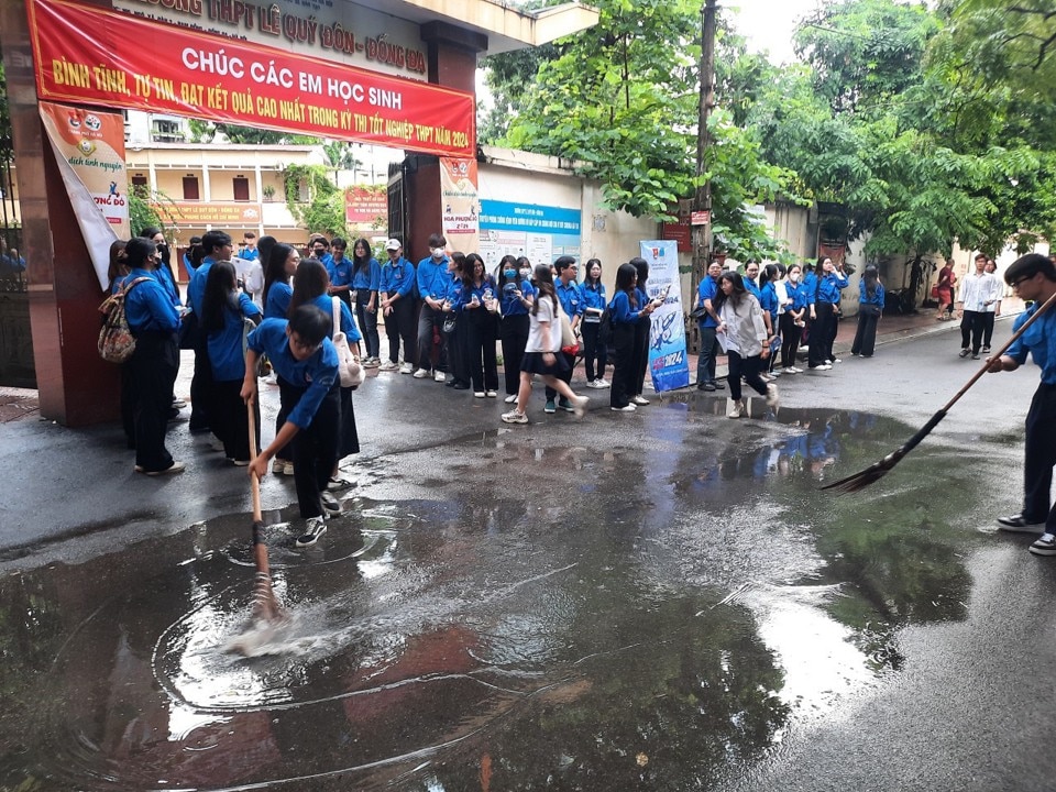Các tình nguyện viên dọn đường để thí sinh thuận lợi vào điểm thi Trường THPT Lê Quý Đôn, quận Đống Đa