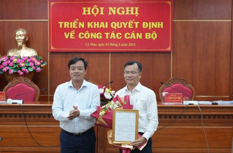 Ông Huỳnh Quốc Việt, Chủ tịch UBND tỉnh Cà Mau trao quyết định điều động cho ông Nguyễn Thế Châu (Hoàng Nam).