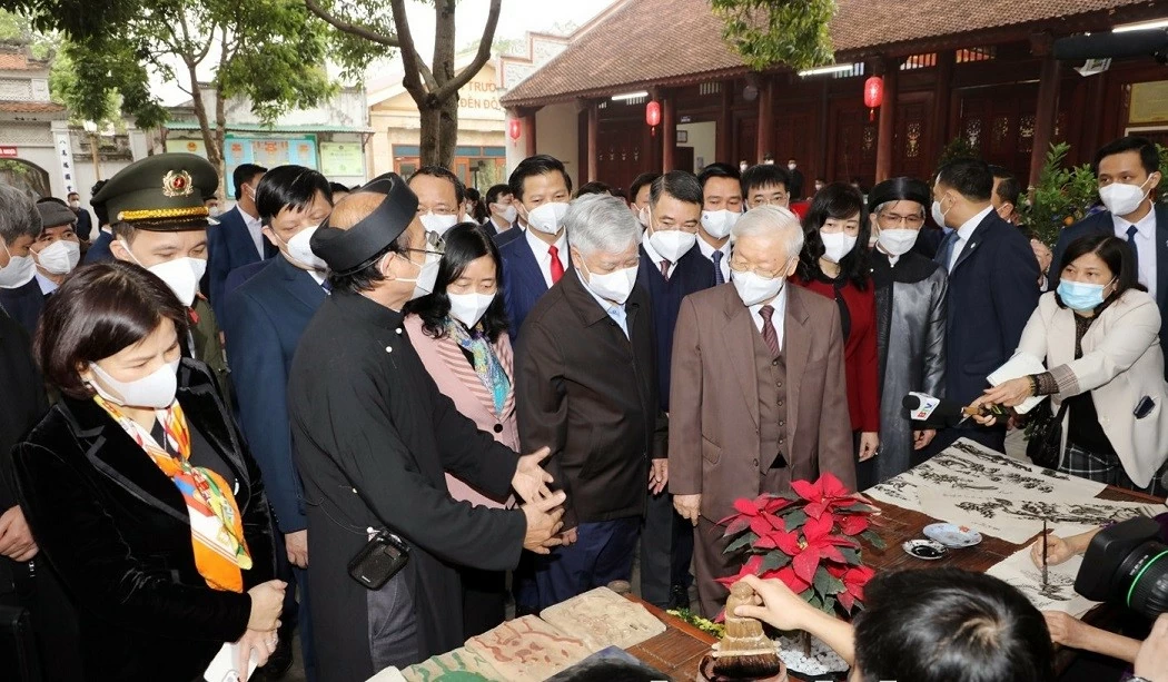 Tổng Bí thư Nguyễn Phú Trọng nghe giới thiệu quy trình làm tranh dân gian Đông Hồ. (Nguồn: bacninh.gov.vn)