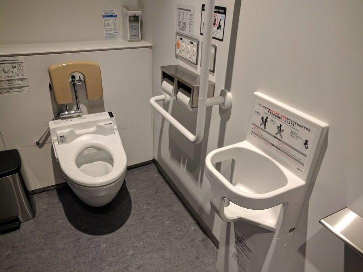 Một khu vực nhà vệ sinh ở Nhật: có phòng vệ sinh riêng cho người già, có tay vịn ngang bồn toilet để người dùng có thể vịn vào khi đứng lên hoặc ngồi xuống, có ghế ngồi cho em bé từ 6 tháng đến 2 tuổi khi đợi mẹ đi vệ sinh - Nguồn ảnh: Mirachan