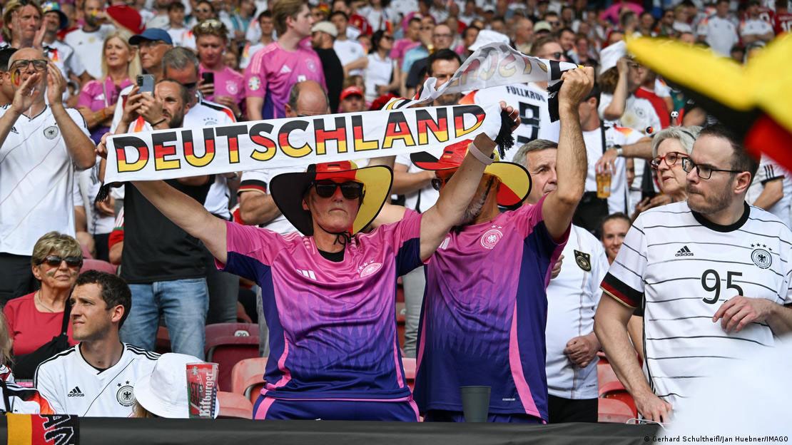 Người hâm mộ đến sân vận động với áo đấu màu hồng cùng chiếc khăn in chữ “Deutschland”