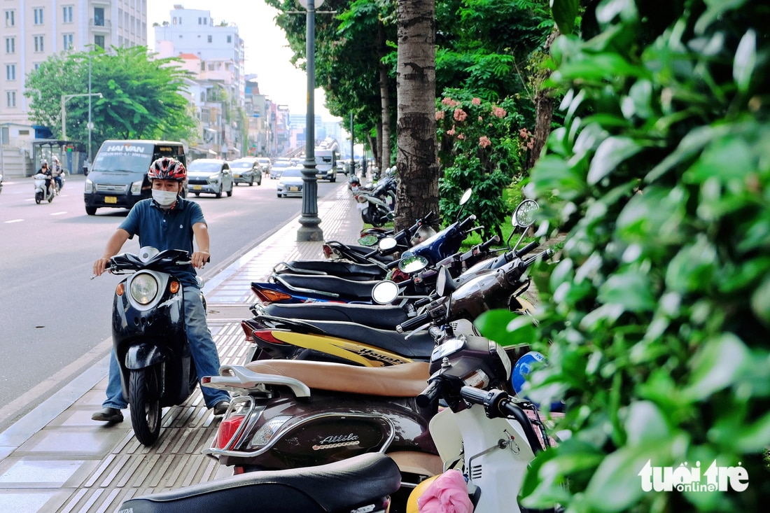 Công viên Hoàng Văn Thụ (quận Tân Bình, TP.HCM) không có bãi giữ xe, người dân đậu đại trên vỉa hè hoặc gửi vào bãi giữ xe tự phát do người bán nước lập ra - Ảnh: PHƯƠNG NHI