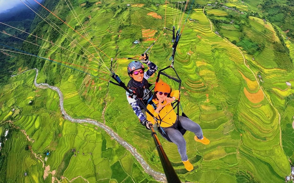 Khách du lịch thích thú trải nghiệm bay dù lượn trên cánh đồng Cao Phạ.